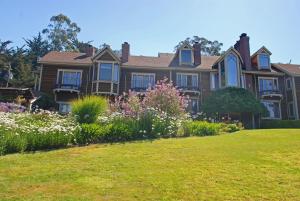 a large house with flowers in the yard at Olema House at Point Reyes in Olema