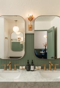 ein Badezimmer mit zwei Waschbecken und zwei Spiegeln in der Unterkunft Petit Soleil - Bed, Breakfast and Bar in San Luis Obispo