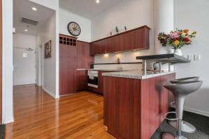 a kitchen with wooden cabinets and a counter top at AWSA Stunning Sea View - 4005 in Auckland