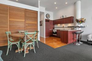 uma cozinha e sala de jantar com mesa e cadeiras em AWSA Stunning Sea View - 4005 em Auckland