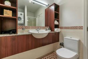 a bathroom with a sink and a toilet and a mirror at AWSA Stunning Sea View - 4005 in Auckland