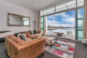 a living room with a couch and a large window at AWSA Stunning Sea View - 4005 in Auckland