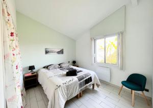sypialnia z łóżkiem, oknem i krzesłem w obiekcie La Villa Capucine w mieście Biscarrosse +33 zdjęcia