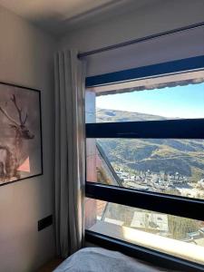Un dormitorio con una ventana con una foto de un ciervo en Apartamento Nordico Monte Oiz, en Sierra Nevada