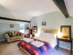 ein Schlafzimmer mit einem großen Bett und einer Couch in der Unterkunft Yew Tree Cottage in Leominster