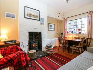 a living room with a fireplace and a dining room table at Yew Tree Cottage in Leominster