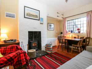ein Wohnzimmer mit einem Kamin und einem Esstisch in der Unterkunft Yew Tree Cottage in Leominster