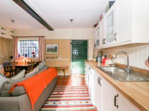 eine Küche mit einem Sofa und einem Tisch darin in der Unterkunft Yew Tree Cottage in Leominster + 21 Fotos