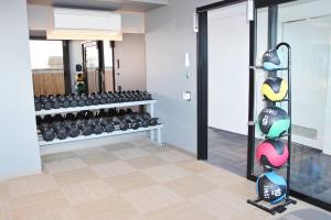 a fitness room with a rack of weights at Luxurious Flemington with Stunning Racecourse View in Melbourne