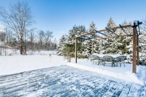 una mesa y sillas cubiertas de nieve con árboles en Spacious Family Home with Deck and Yard 5 Mi to Stowe, en Morristown