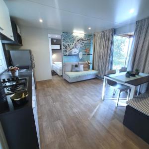 een keuken en een woonkamer met een tafel en een bank bij Mobile House 4 you, Camp Rehut in Murter