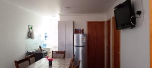 a kitchen with a table and a refrigerator at Cabañas Tres Islas in Punta de Choros