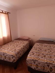 - une chambre avec 2 lits et une fenêtre dans l'établissement Cabañas Tres Islas, à Punta de Choros