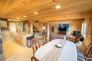 una sala da pranzo e una cucina in una baita di tronchi di Keystone Lodge - Private Log Home a Mora