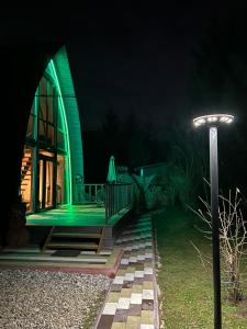 una luz verde en el lateral de una casa por la noche en U Yaroslava Hotel, en Yaremche
