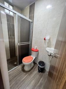 een badkamer met een douche en een toilet met een rood deksel bij Quinta la moro in Melgar