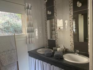 a bathroom with two sinks and a window at Escargot de Neige in La Bresse