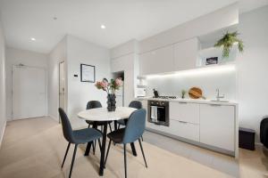 Una cocina y un comedor con mesa y sillas. en A Cosmopolitan Hub in CBD Centre, en Melbourne 15 fotos más