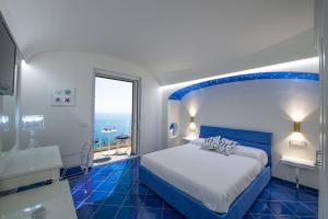 a blue and white bedroom with a bed and a window at Holidays dream Praiano in Praiano