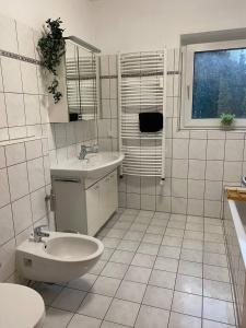 uma casa de banho branca com um lavatório e um WC em Haus mit Garten - Kingbett - WIFI - Parkplatz em Essen