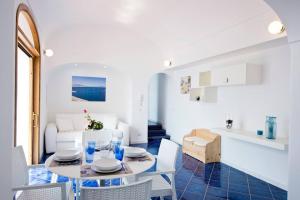 ein weißes Wohnzimmer mit einem Tisch und Stühlen in der Unterkunft Holidays dream Praiano in Praiano