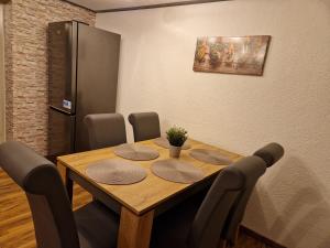 a dining room table with chairs and a refrigerator at Ferienwohnung/Monteurunterkunft 2.0 Leopolshall in Staßfurt