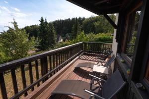 einen Balkon mit Stühlen und Waldblick in der Unterkunft Sonnige Aussicht in Waldhölzbach