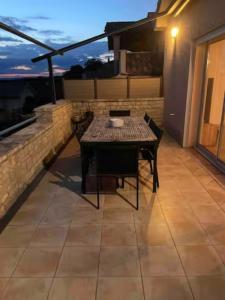 a patio with a table and chairs on a balcony at Maëliette in Montclus