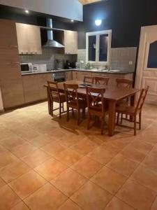 cocina con mesa de madera y sillas de madera en Maëliette en Montclus