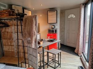 a small kitchen with a table and a red refrigerator at L Atypic, chalet bien être aux portes de Vannes in Monterblanc