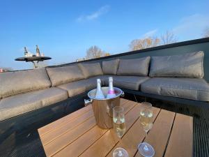a table with two bottles and two glasses on a patio at GREEN VILLA in bester Lage - Dachterrasse mit Meerblick - großer eingezäunter Garten - kinderfreundlich - Hunde inklusive - 4 Sterne Resort - direkt am Strand - Pool inklusive in Hulshorst
