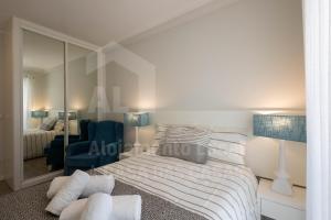 1 dormitorio con cama y espejo en Ribas Apartment by ACasaDasCasas, en Ericeira
