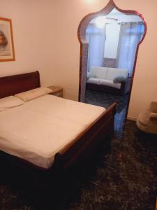 um quarto com uma cama, um espelho e um sofá em ESTRELLA LOUNGE em Benalmádena