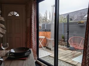 una casa con puerta de cristal y vistas al patio. en L Atypic, chalet bien être aux portes de Vannes, en Monterblanc
