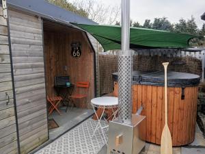 a bar with a green umbrella on a patio at L Atypic, chalet bien être aux portes de Vannes in Monterblanc