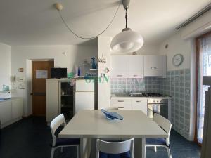 eine Küche mit einem weißen Tisch, einem Tisch und Stühlen in der Unterkunft CONCHIGLIA in San Vincenzo + 17 Fotos