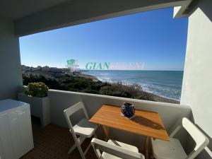 ein Tisch und Stühle auf einem Balkon mit Blick auf das Meer in der Unterkunft CONCHIGLIA in San Vincenzo