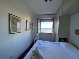 ein Schlafzimmer mit einem Bett mit Blick auf das Meer in der Unterkunft CONCHIGLIA in San Vincenzo