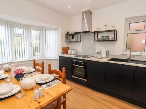a kitchen with a wooden table and a dining room at Field Cottage in York