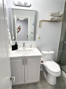 Baño blanco con aseo y lavamanos en Cozy & Comfortable basement apartment, en Mississauga