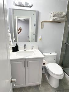 a white bathroom with a toilet and a sink at Cozy & Comfortable basement apartment in Mississauga +17 photos