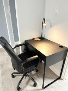 a black desk with a chair and a lamp at Cozy & Comfortable basement apartment in Mississauga