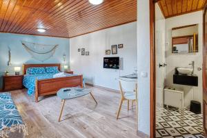 a bedroom with a bed and a desk and a table at Ocean Blue & Nature Townhouse - Bikes included in Ericeira