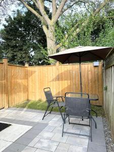 a table and chairs with an umbrella on a patio at Cozy & Comfortable basement apartment in Mississauga