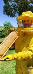 Um homem de fato amarelo segurando uma sanduíche. em Pousada Mirante dos Ipês - Capitólio - MG em Capitólio