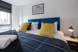 a bedroom with a bed with yellow pillows on it at Stylish Northern Quarter 2Bed, Free Parking, WI-FI, Sleeps 4, Central Location, Long term Disc in Manchester