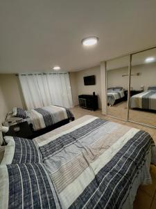 een slaapkamer met 2 bedden en een grote spiegel bij Beach Front Studio Apartment with Pool in Isabela