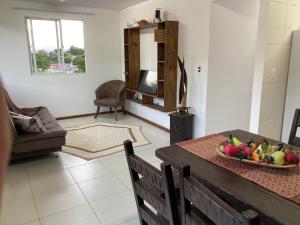 una sala de estar con una mesa con un bol de fruta. en Recanto das Pedras Floripa, en Florianópolis