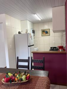 a kitchen with a table with a bowl of fruit on it at Recanto das Pedras Floripa in Florianópolis