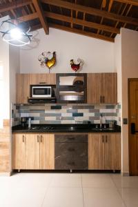 a kitchen with wooden cabinets and a microwave at Lindo apartamento con terraza en Bello Ant in Bello